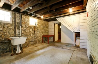 Unfinished basement with old sink and stone walls
